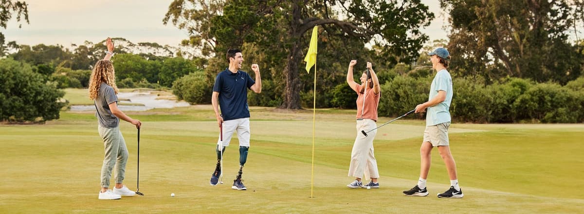 Four golfers celebrating on a green