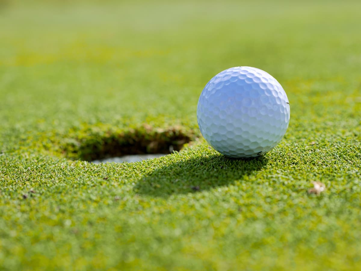 A golf ball on the lip of the hole