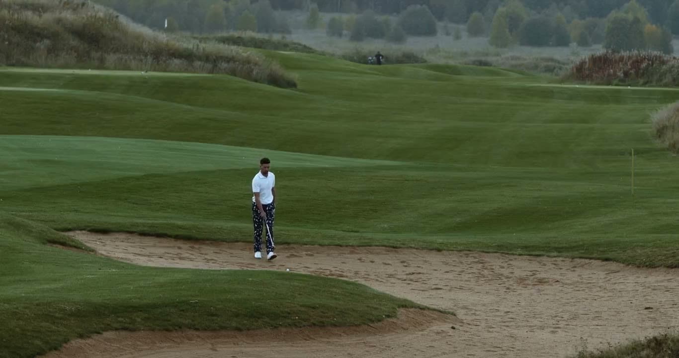 A golfer playing out of a bunker