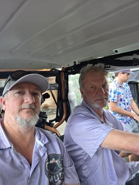 Two players in a cart between holes