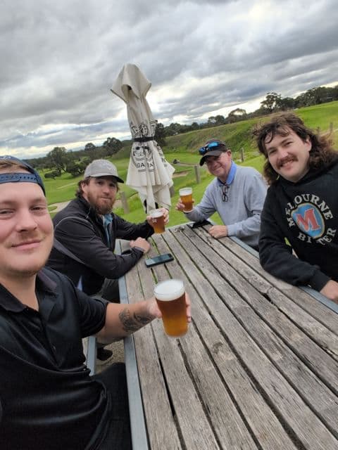 Players at an outdoor table with a beer