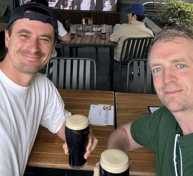 Two players with a beer in the clubhouse