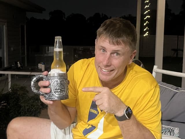 A player holding up a stubby in a holder